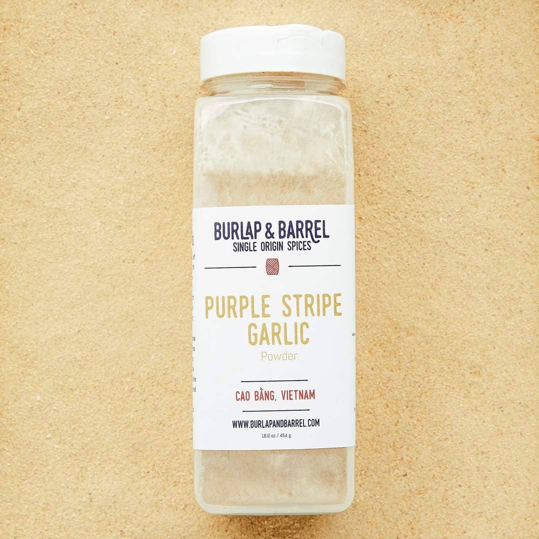Bottle of Burlap & Barrel Purple Stripe Garlic on a beige background