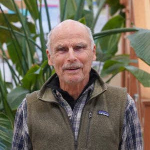 Man wearing a Patagonia vest standing in front of green plants