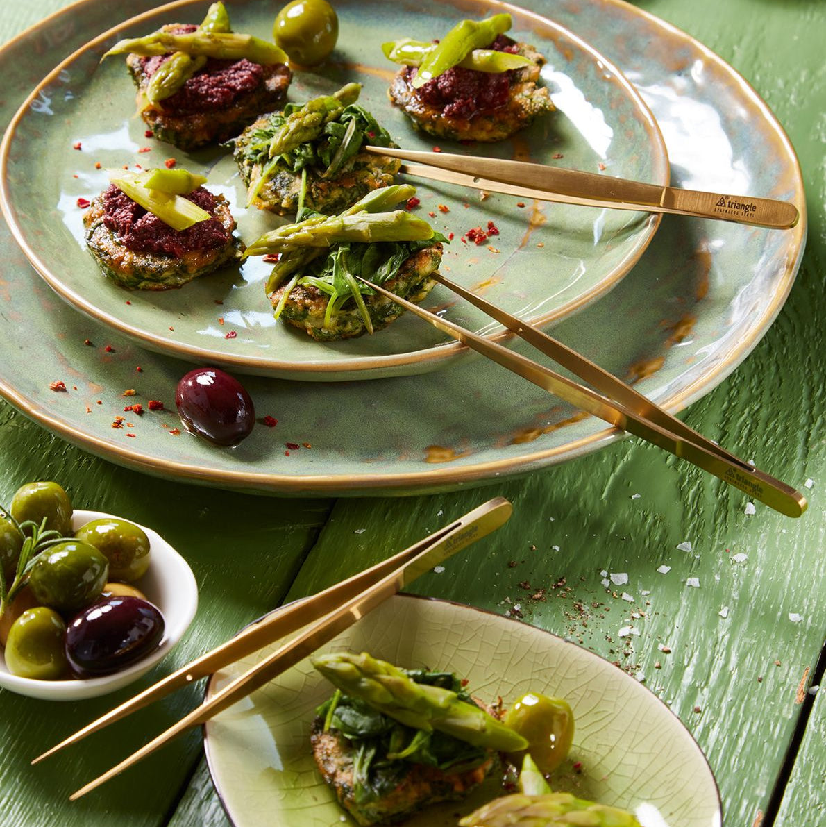 Plates of food with chopsticks on a green wooden table