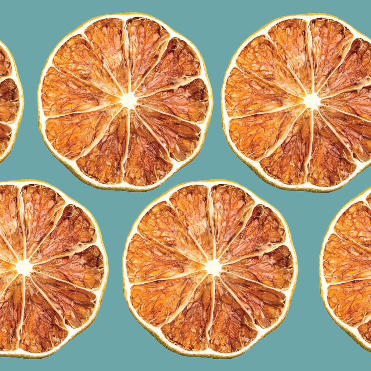 Pattern of dried lime slices on a teal background
