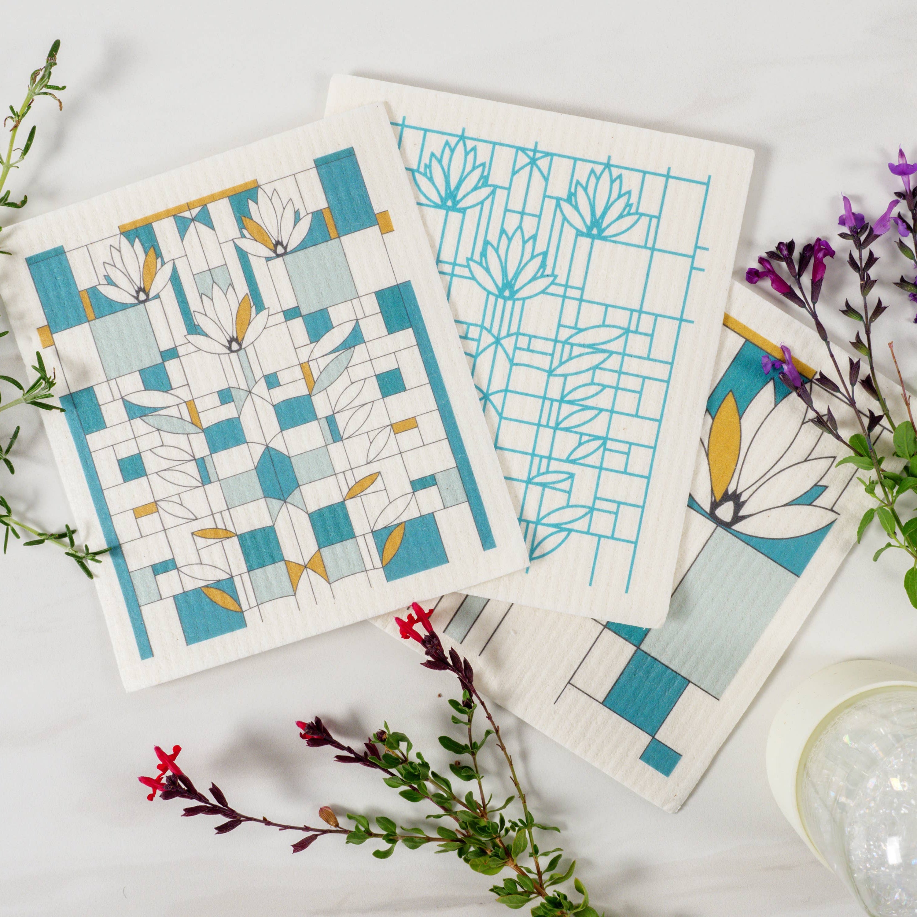 Set of three fabric swatches with geometric patterns on a white background with plants.