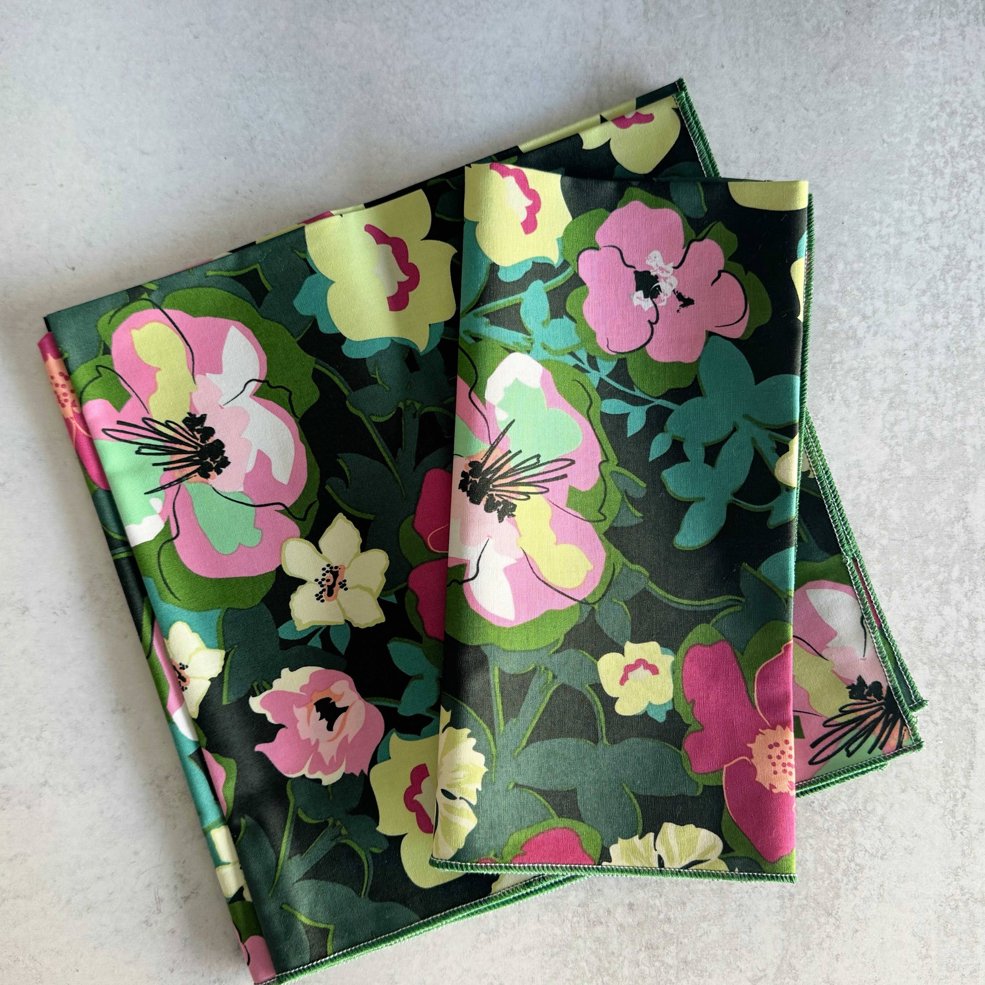 Two floral-patterned notebooks stacked on a light gray surface