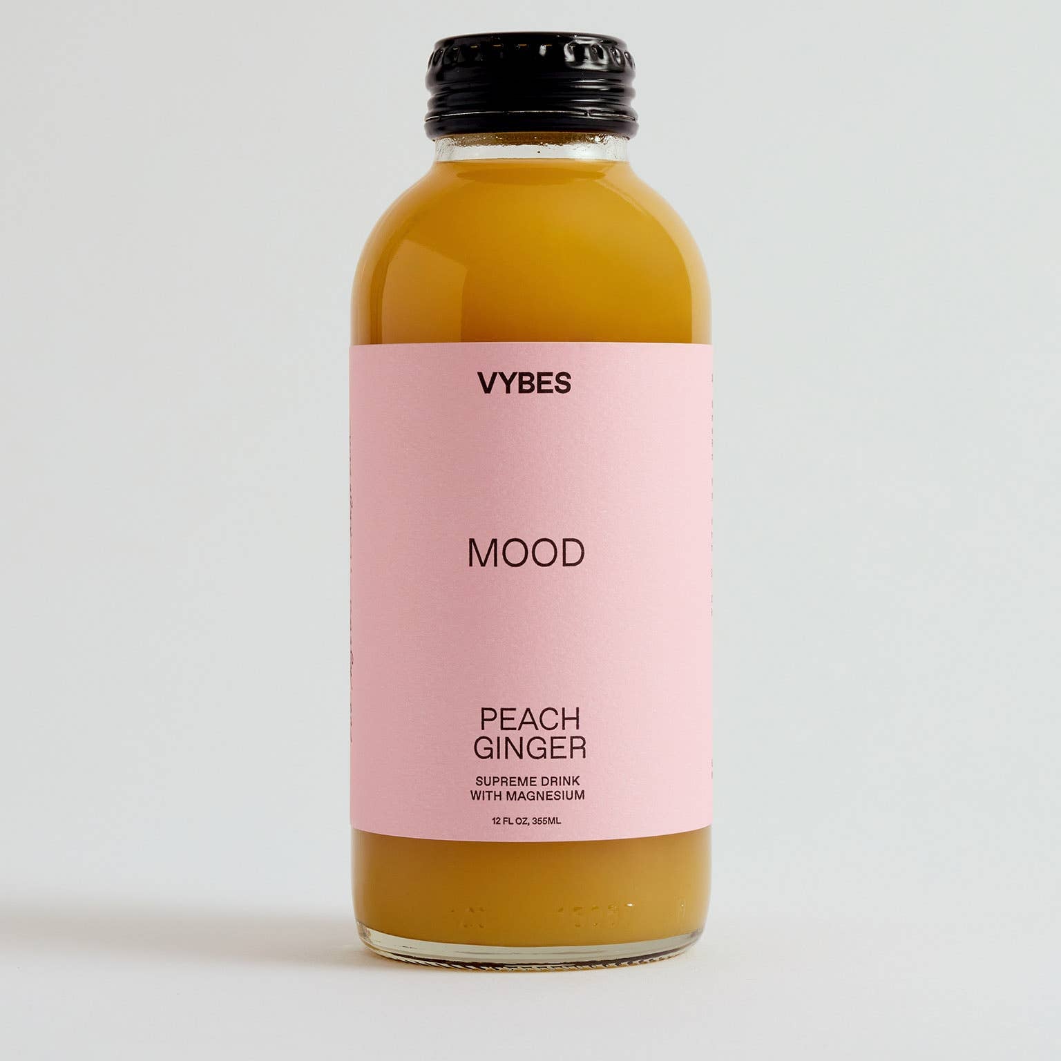 Bottle of VYBES Peach Ginger on a light gray background