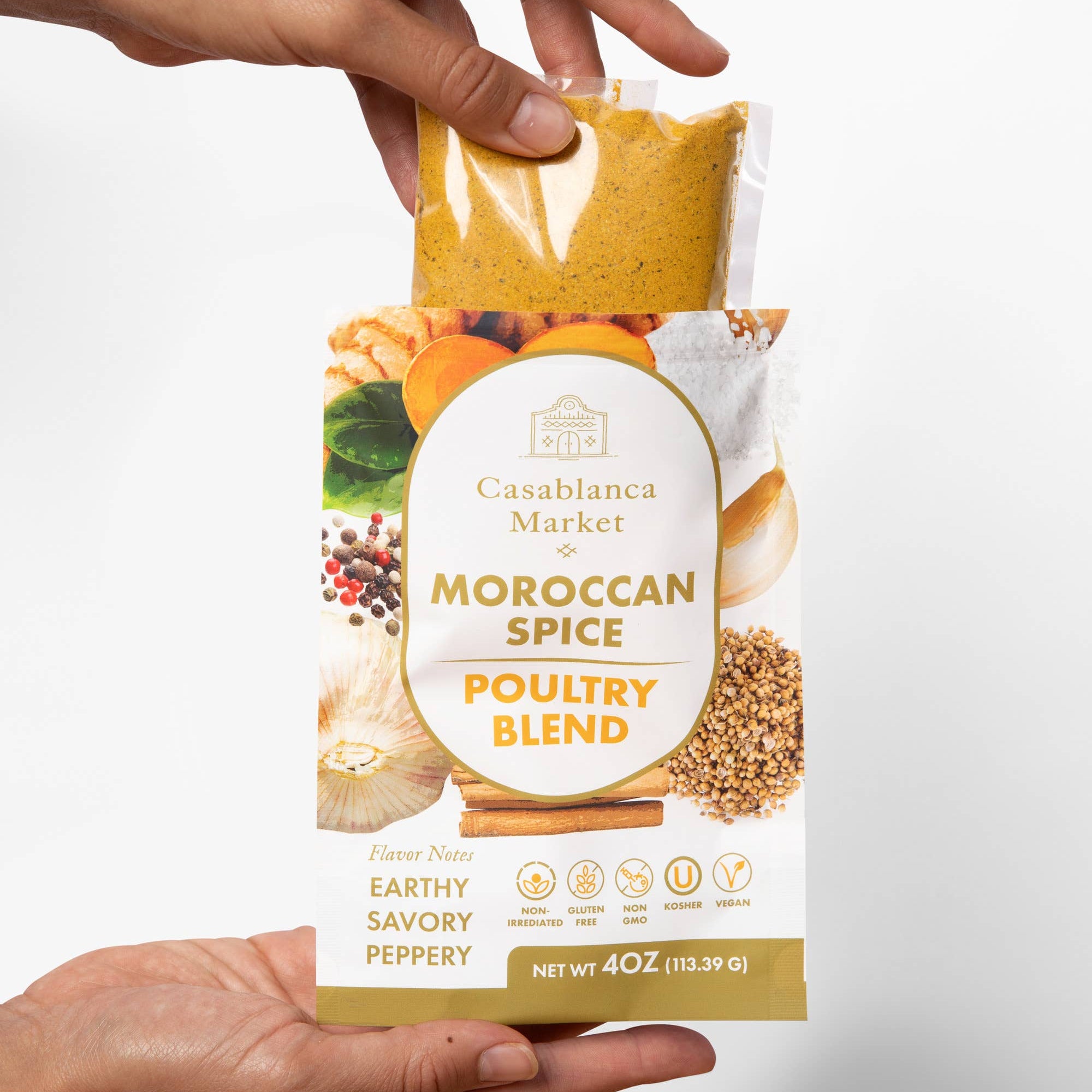 Hand holding a package of Casablanca Market Moroccan Spice Poultry Blend against a white background