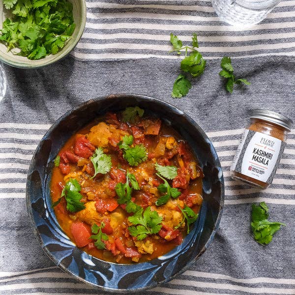 bowl of curry with kasuri methi masala on a striped fabric background