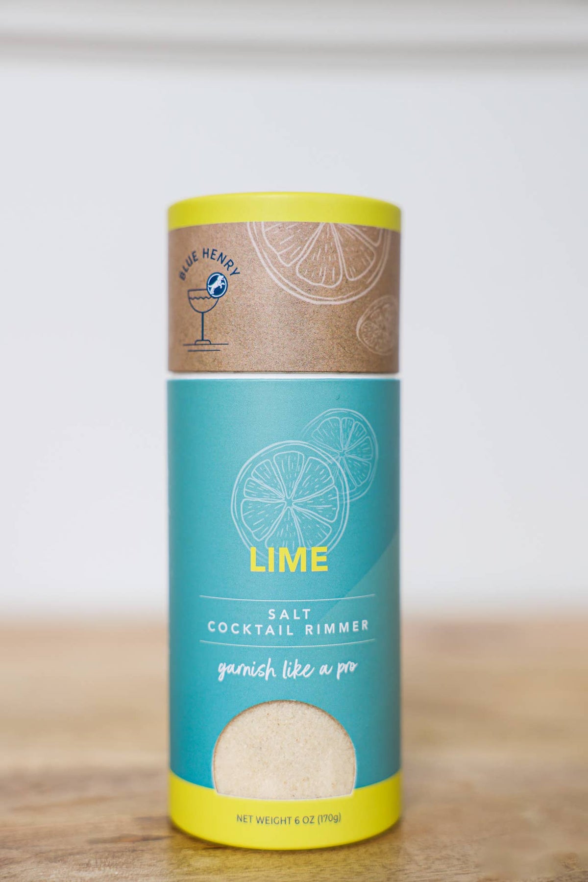 Container of lime cocktail rimming salt on a wooden surface