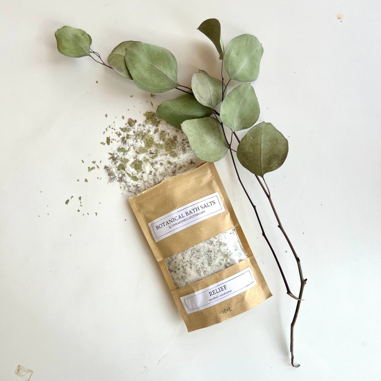 Bag of botanical bath salts with eucalyptus leaves on a white background