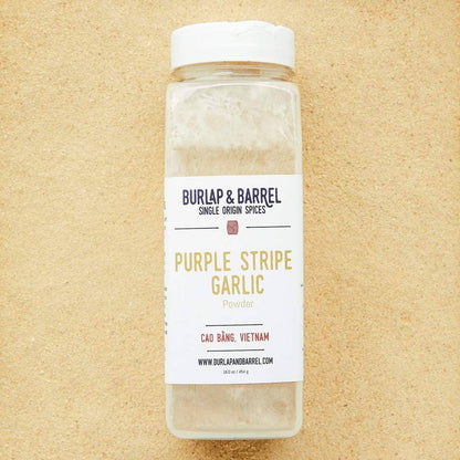 Bottle of Burlap &amp; Barrel Purple Stripe Garlic on a beige background