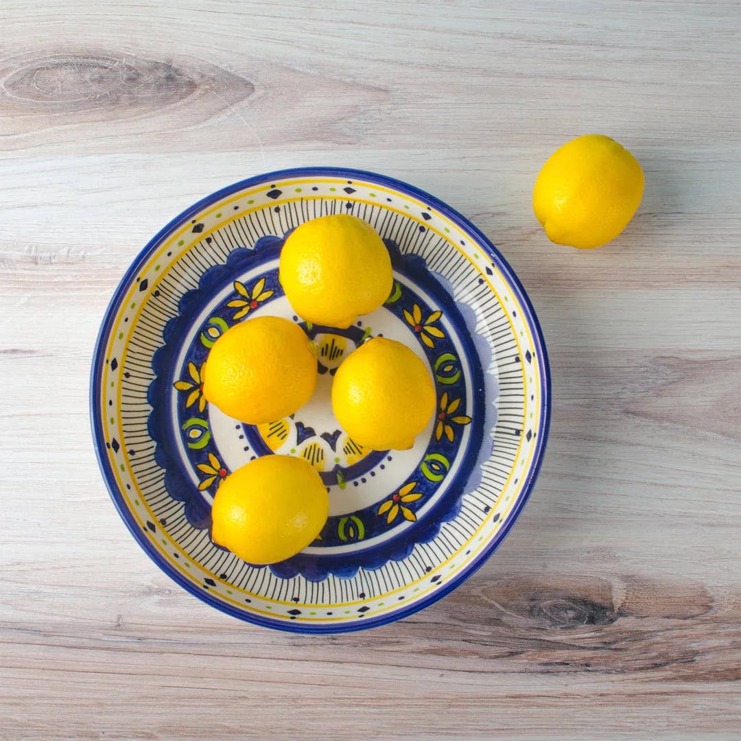 Decorative bowl with lemons on a wooden surface