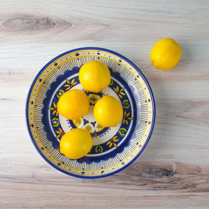 Decorative bowl with lemons on a wooden surface
