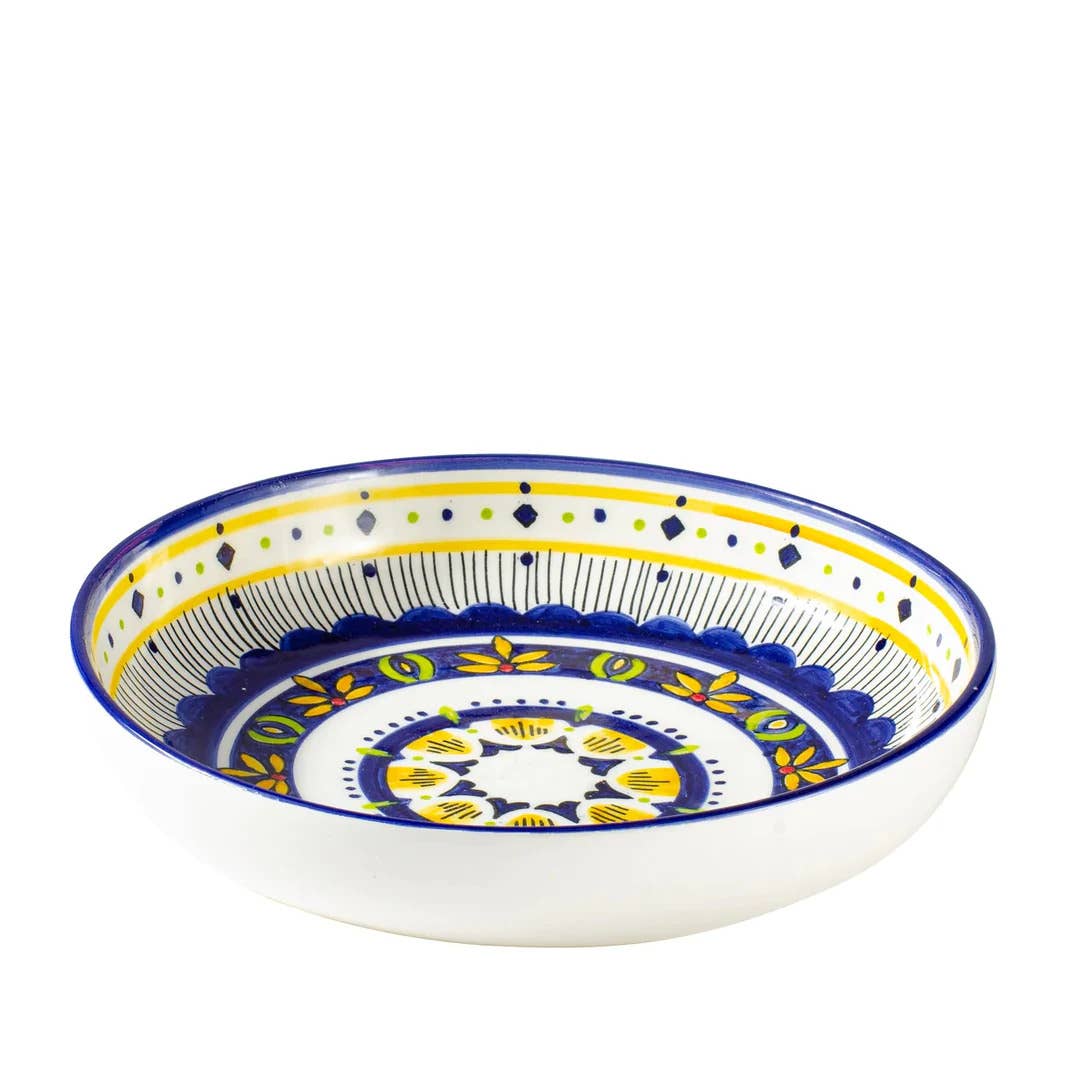 Decorative ceramic bowl with blue and yellow patterns on a white background