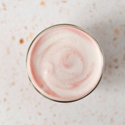 Glass with pink and white swirl on a light speckled surface