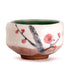 Ceramic cup with cherry blossom design on a white background