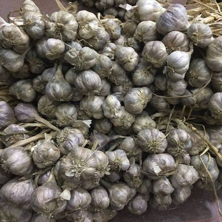 Close-up of a pile of garlic bulbs on a wooden surface