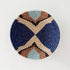 Round woven basket with geometric pattern on a white background