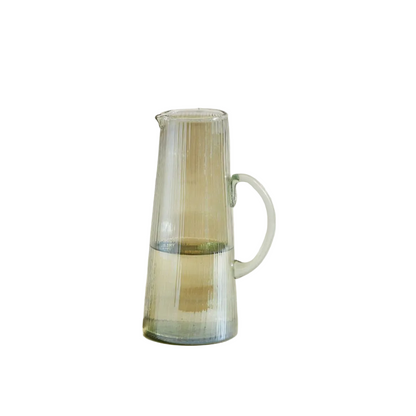 A ribbed clear glass pitcher with a handle and pouring spout, shown on a plain white background.