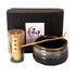 Tea-making set with black bowl, whisk, and holder against a white background
