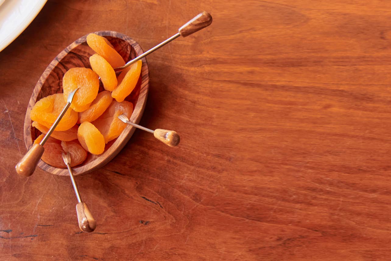 Italian Olivewood Aperitivo Bowl filled with dried apricots on skewers