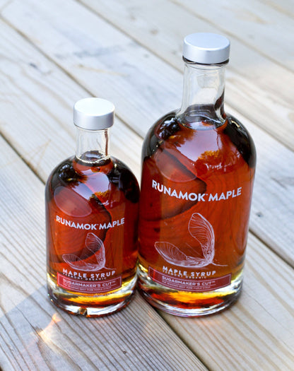 Two bottles of Runamok Maple syrup on a wooden surface