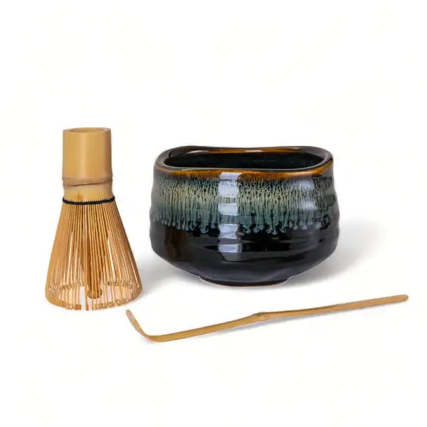 Ceramic tea bowl with bamboo whisk and spoon on a white background