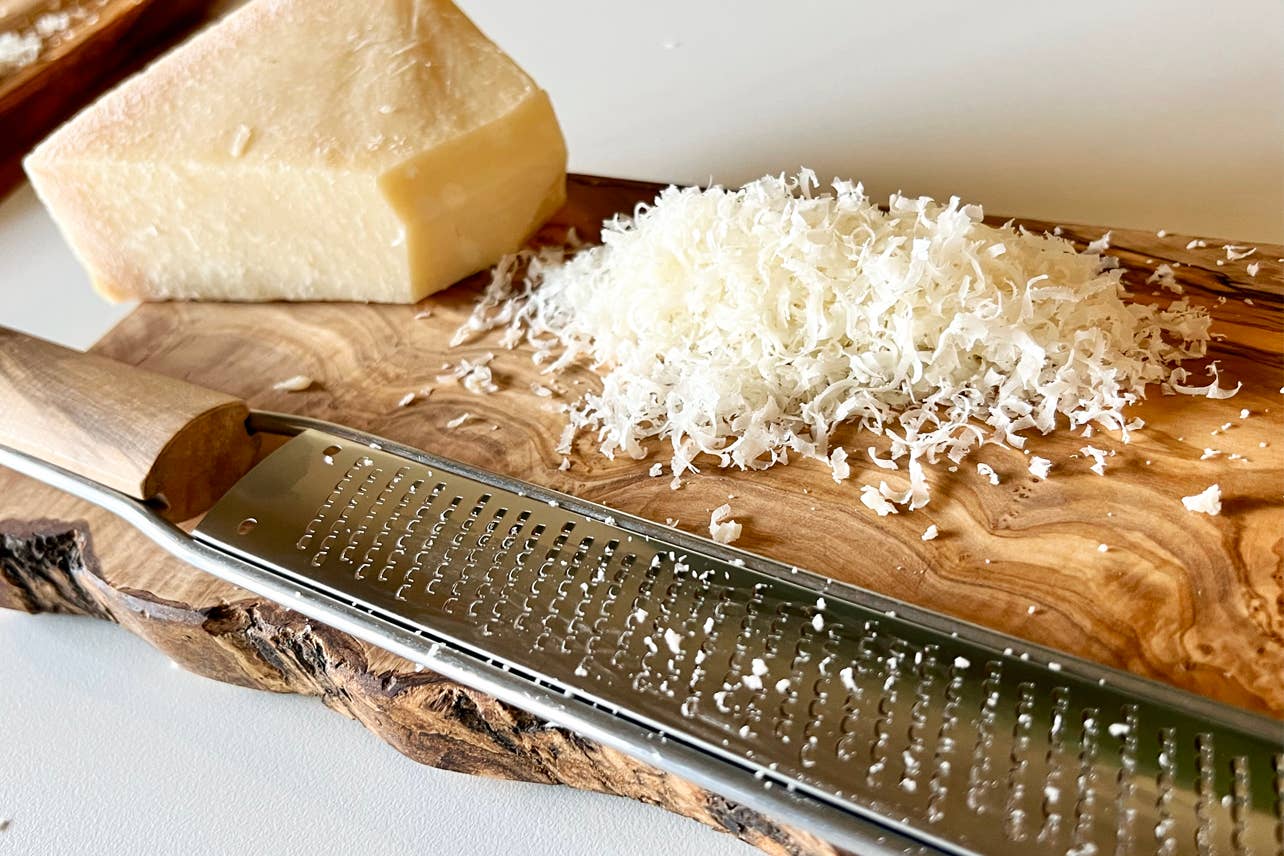 Close up of a fine Italian Mandolin Paddle Grater with grated cheese
