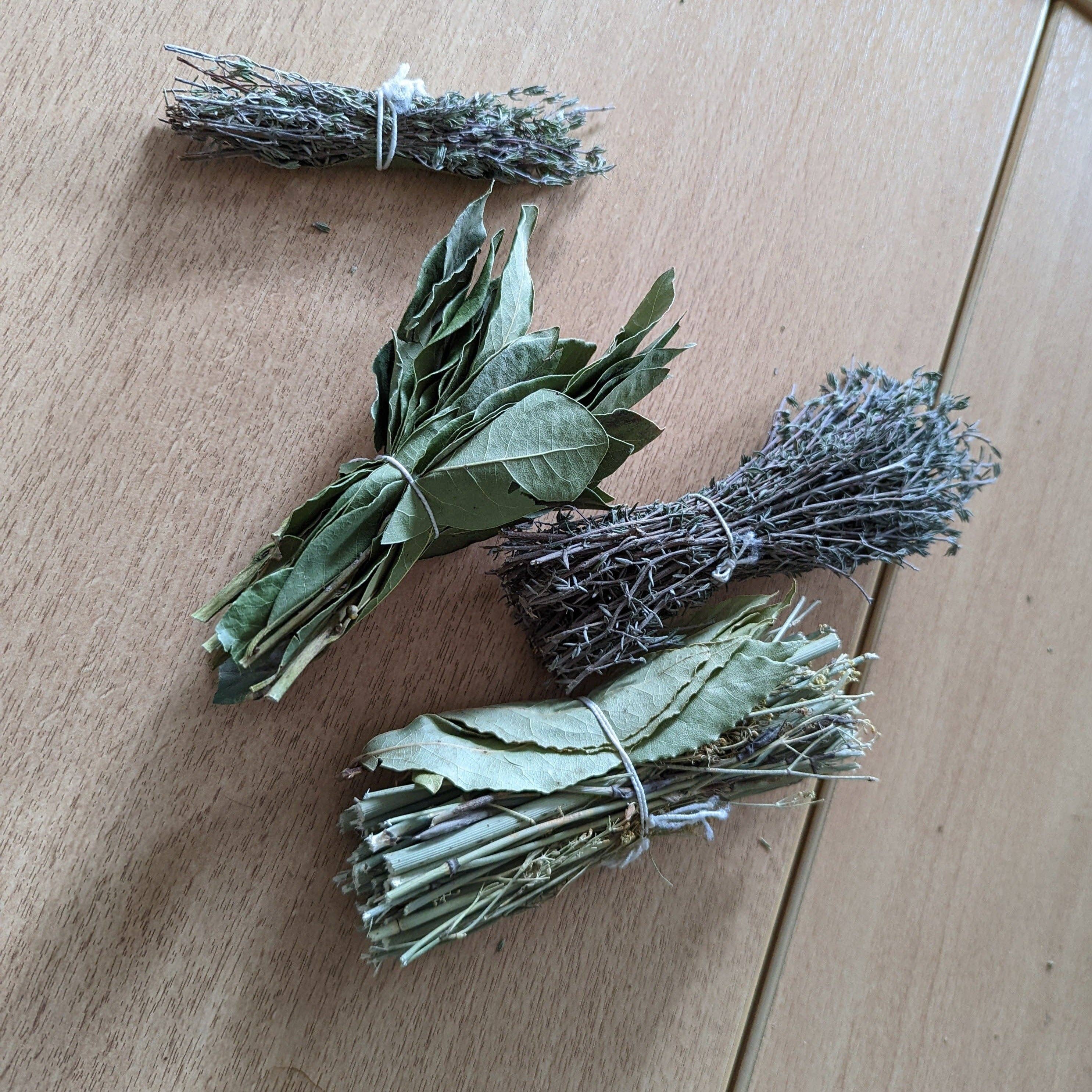 Bundles of dried herbs on a wooden surface
