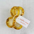 Set of four amber-colored napkin rings with a tag on a light gray background