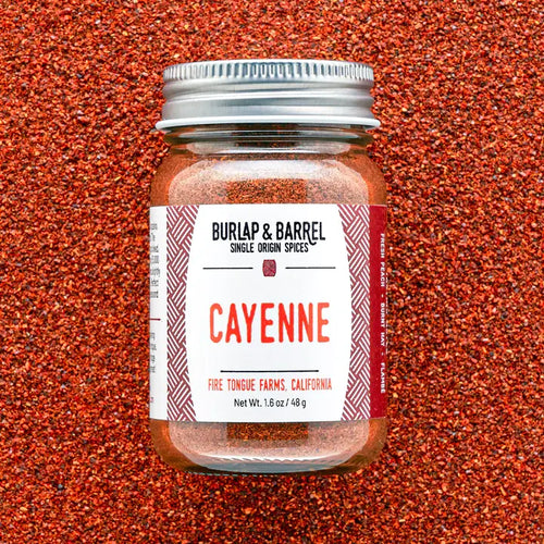 Jar of cayenne pepper with 'Burlap & Barrel' label on a red textured background