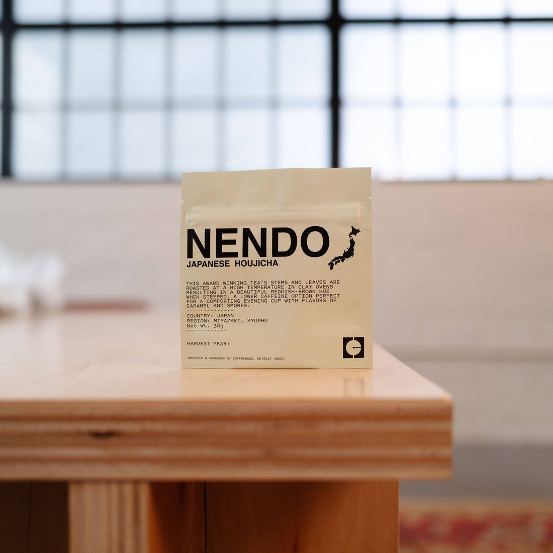 Nendo Japanese Houjicha tea package on a wooden surface with a blurred background