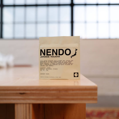Nendo Japanese Houjicha tea package on a wooden surface with a blurred background