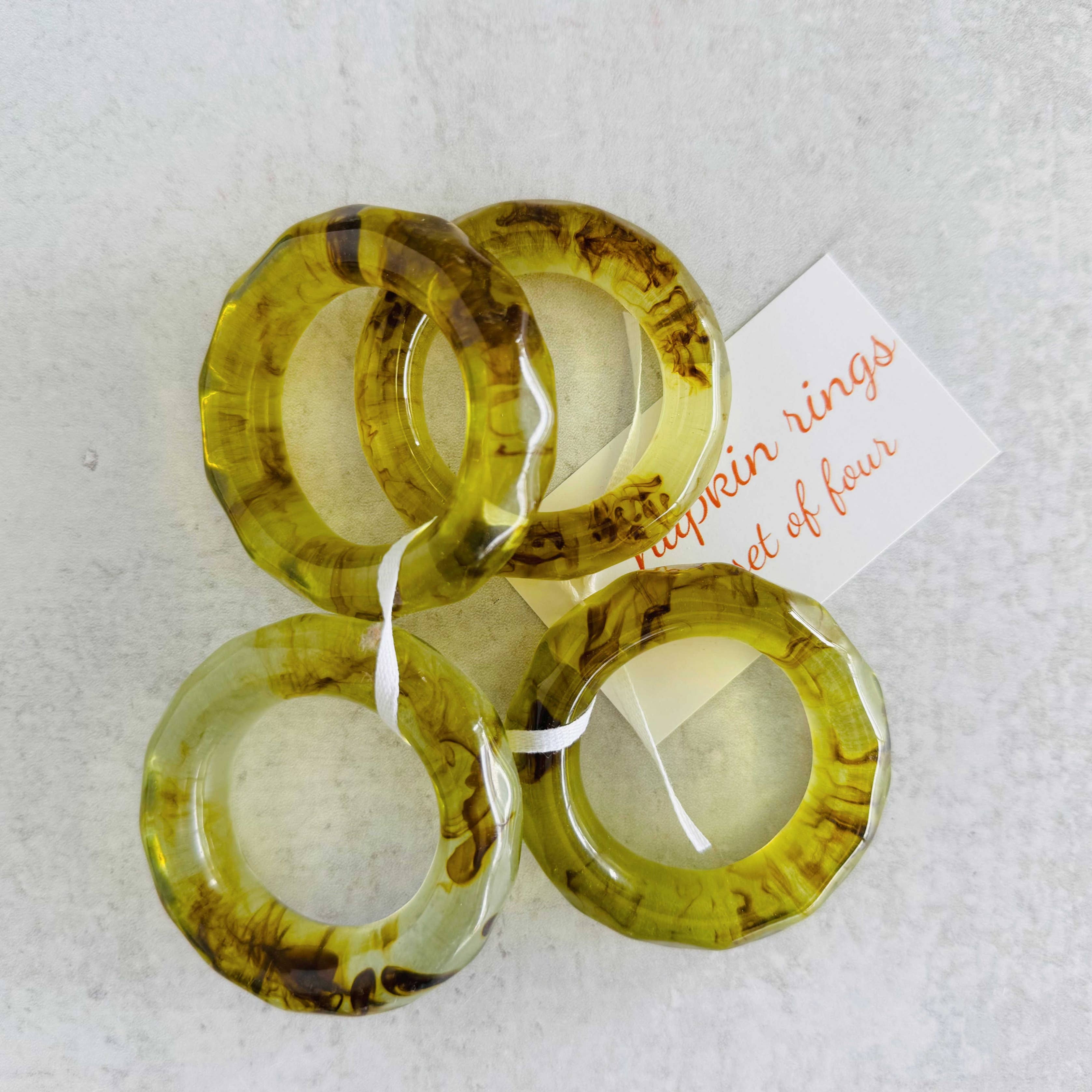 Set of four yellow rings with a tag on a light gray background