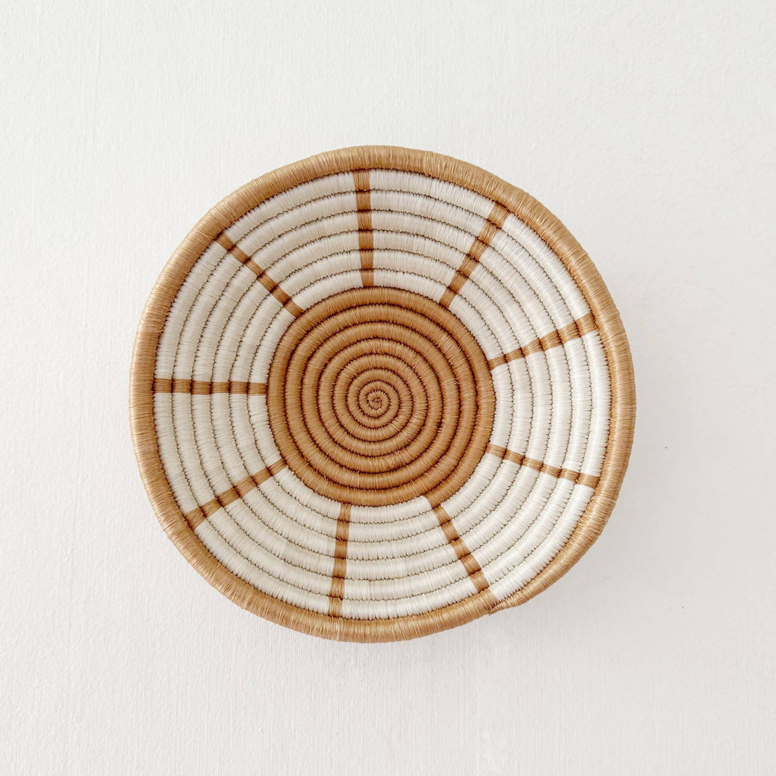 Woven basket with concentric circle pattern on a white background