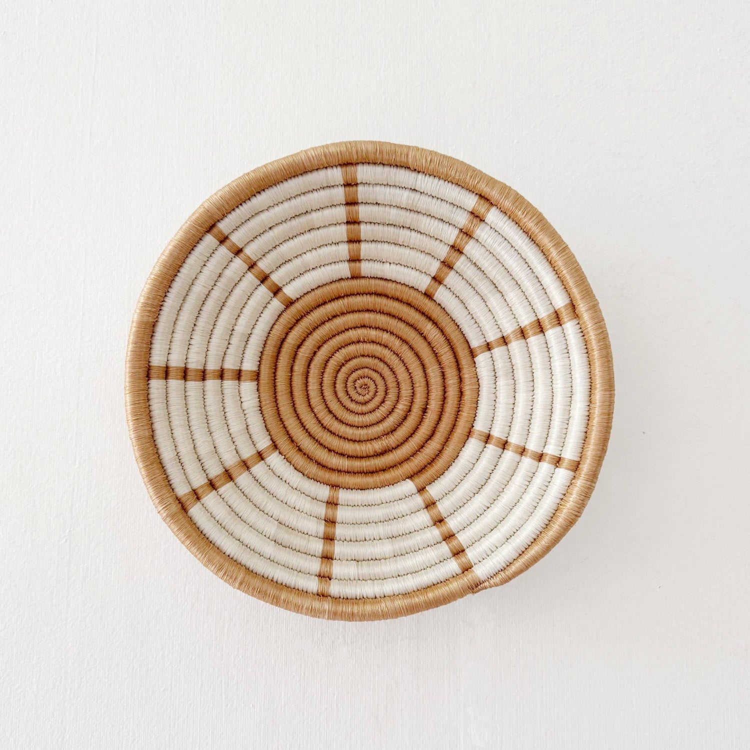 Woven basket with concentric circle pattern on a white background