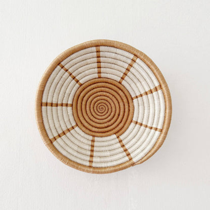 Woven basket with concentric circle pattern on a white background