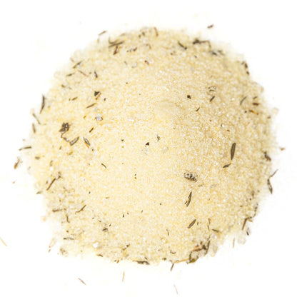 A small mound of lemon-thyme sugar &amp; salt cocktail rimmer with visible dried herb flecks, photographed from above on a plain white background.