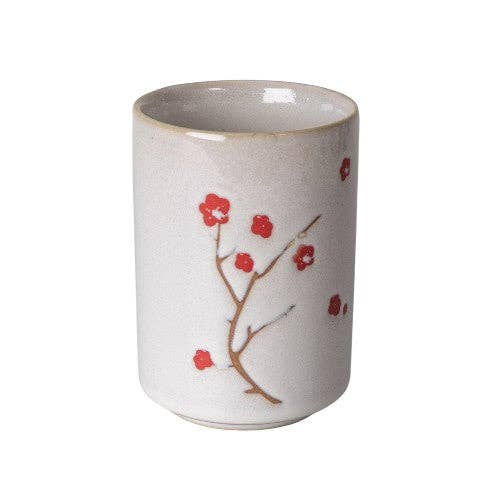 White ceramic cup with red floral design on a white background