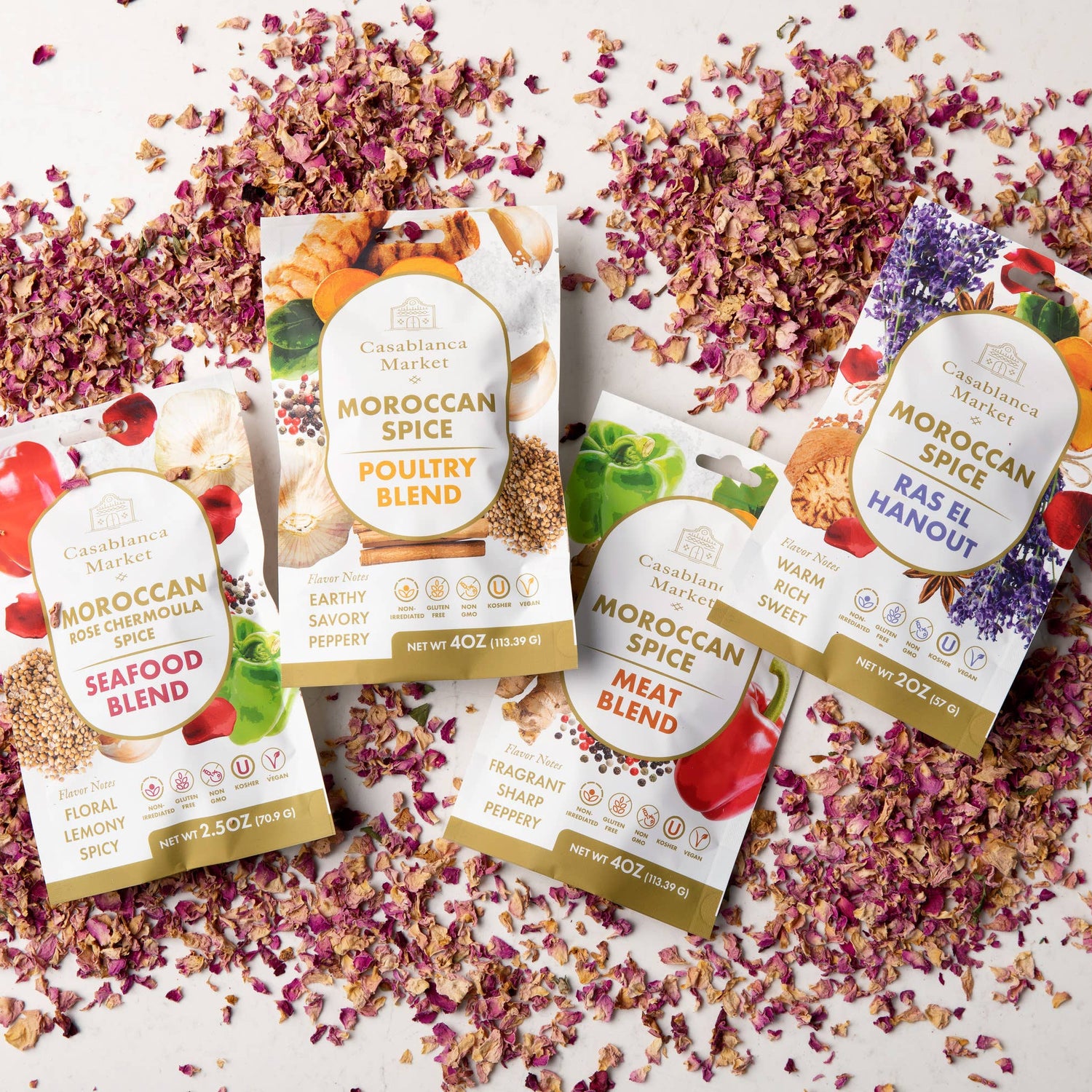 Moroccan Spice seasoning packages on a white surface with dried flowers.
