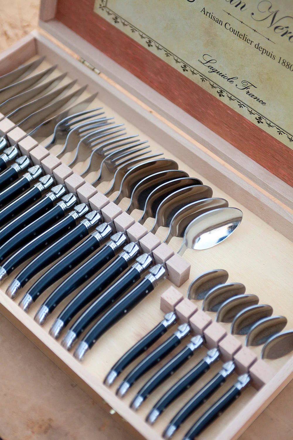 Set of silverware in a wooden box with a visible brand name.