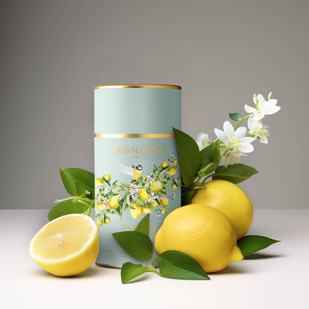 Tea canister with lemon design surrounded by lemons and flowers on a neutral background