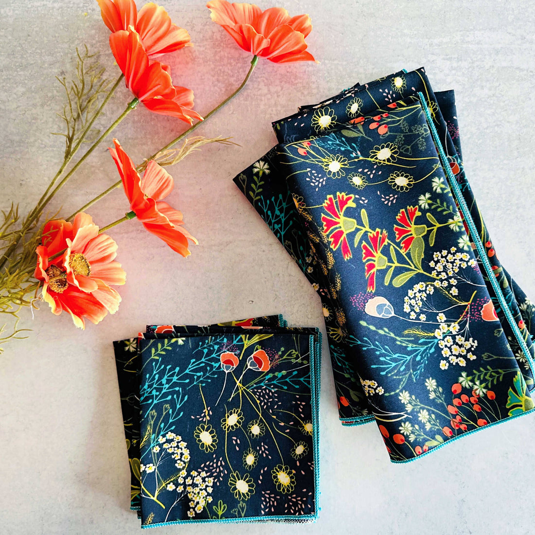 Folded floral-patterned fabric with orange flowers on a light background
