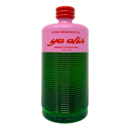A glass bottle of Ya Albi Extra Virgin Olive Oil, featuring a two-tone design with a pink upper label and cap, and a ribbed green lower body, isolated on a white background.