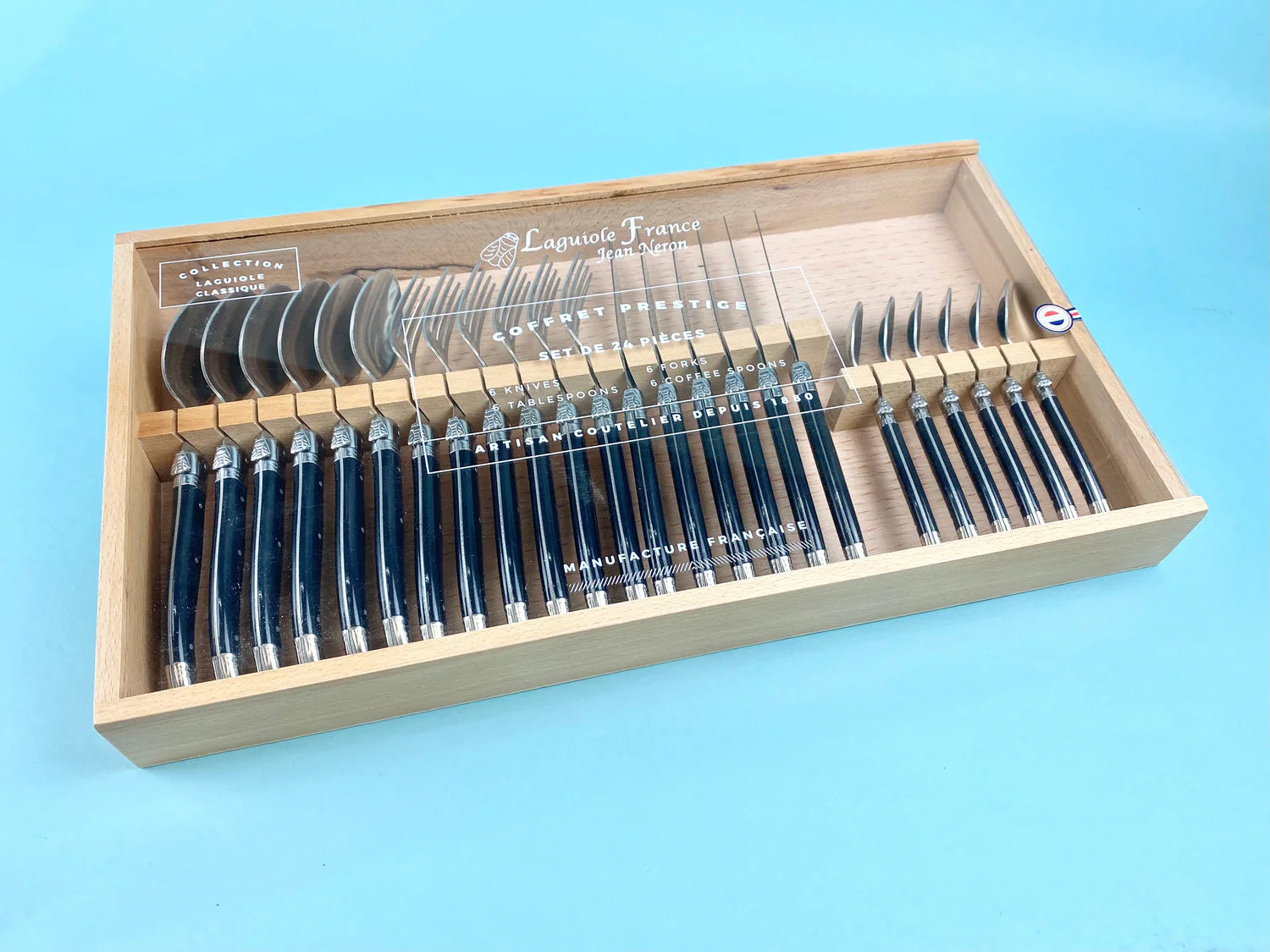 Set of steak knives in a wooden box on a blue background