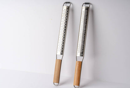 Set of coarse and fine Italian Mandolin Paddle Graters with wood handles on a white background