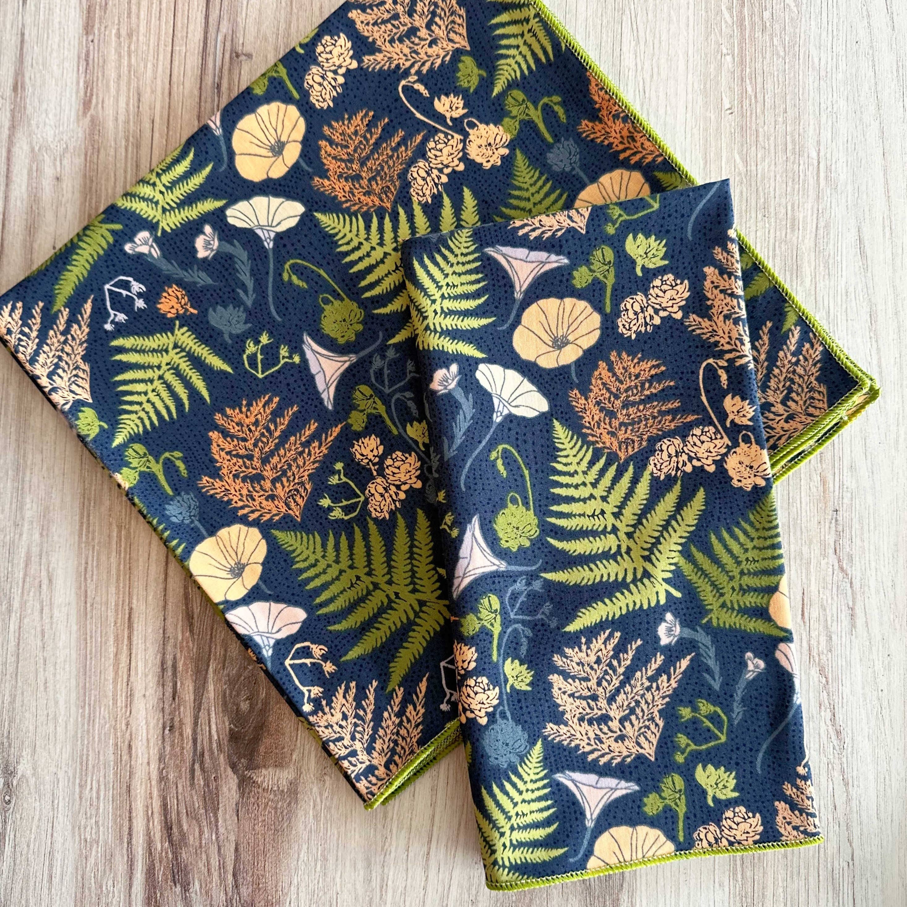 Two floral-patterned napkins on a wooden surface