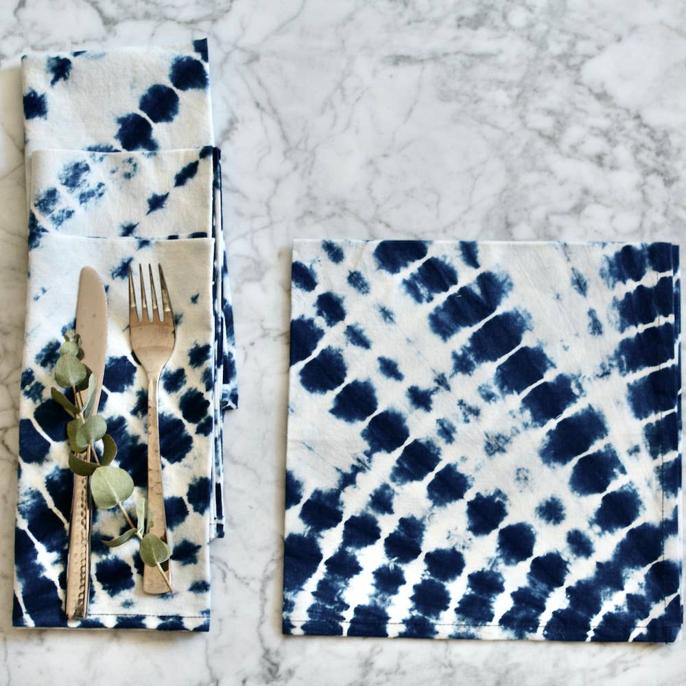 Napkin with blue and white tie-dye pattern on a marble surface