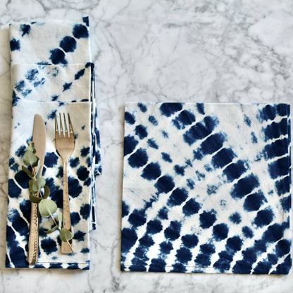 Napkin with blue and white tie-dye pattern on a marble surface