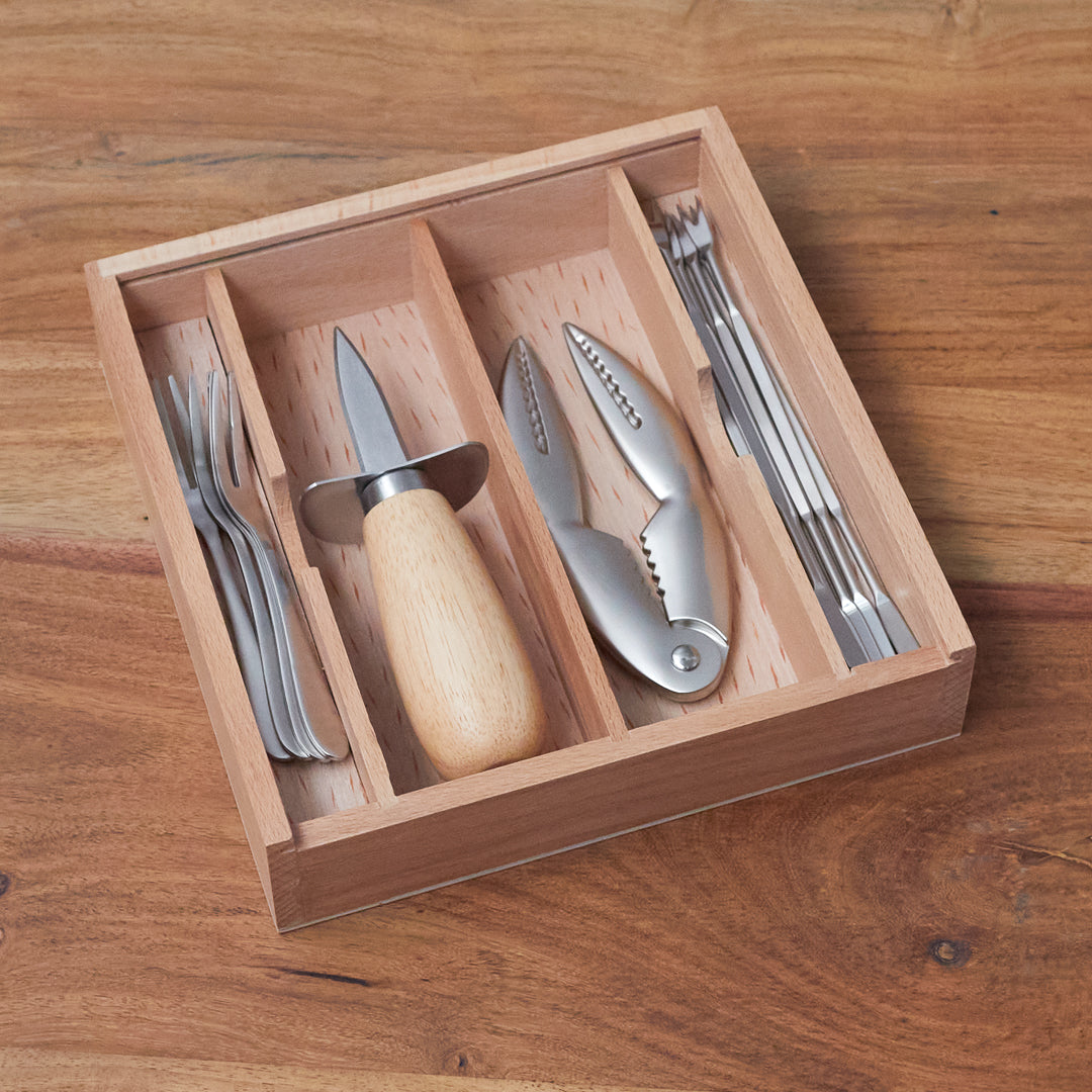 Set of cutlery in a wooden organizer on a wooden surface