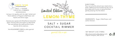 A square product label for the Blueberry Lemon Thyme Salt + Sugar Cocktail Rimmer, featuring a white background with blue and yellow text, botanical illustrations, and a central &