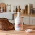 Brightland olive oil bottle on a kitchen counter with bread and salt
