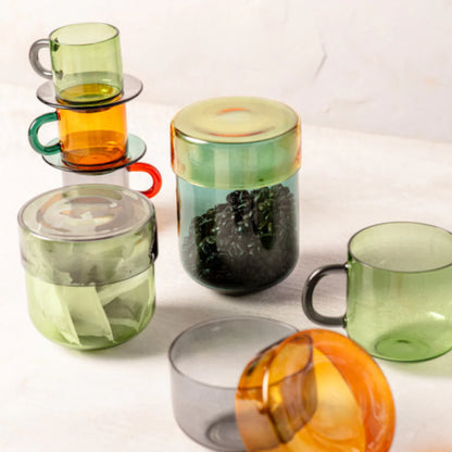 Set of colorful glass mugs and containers on a white background